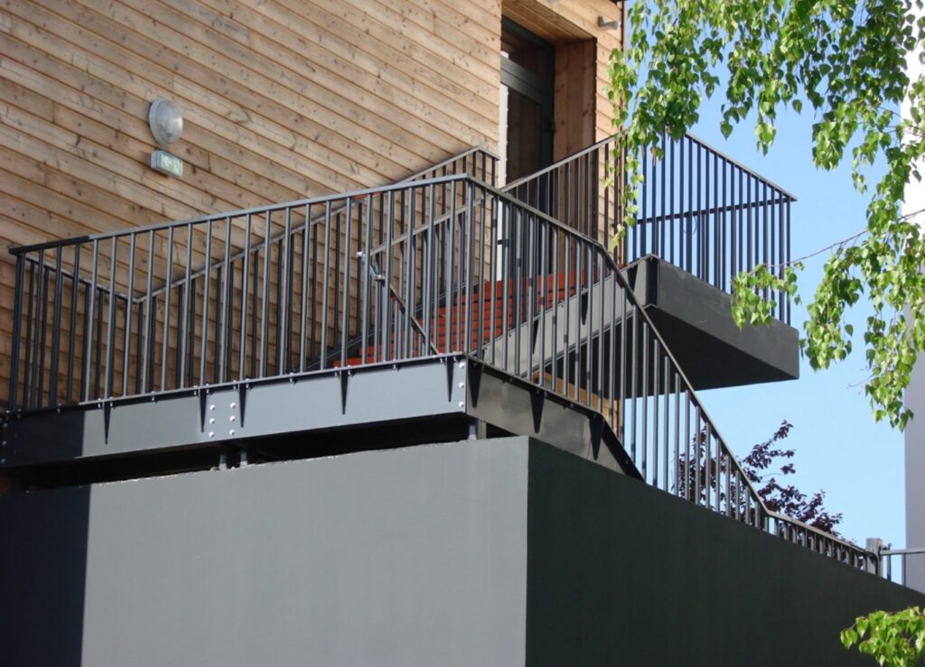 escaliers sur mesure extérieurs et garde corps en métal. Le bâtiment est en bois.